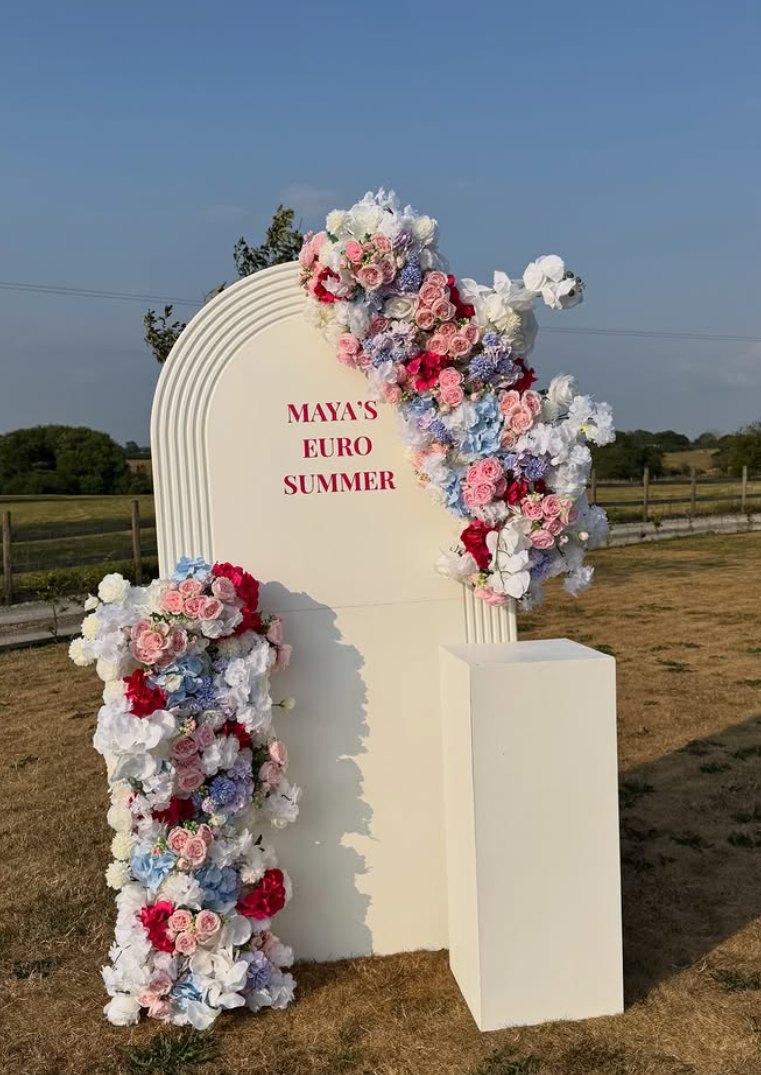 Cream arch board dressed with pink, blue and white florals styled outdoors by Ta Luxe Events