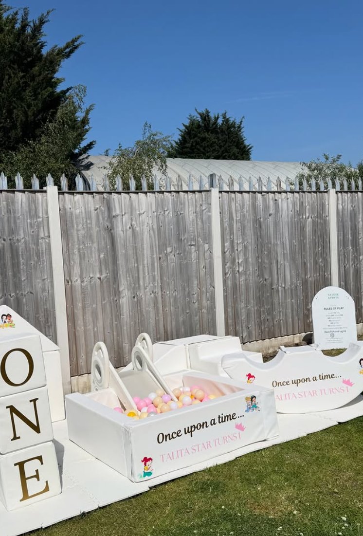 White luxury soft play set with a pastel ball pit, rockers and slide on a garden lawn